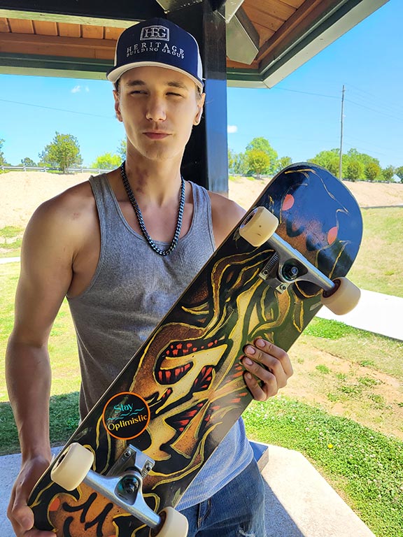 Skater holding skateboard while looking at camera